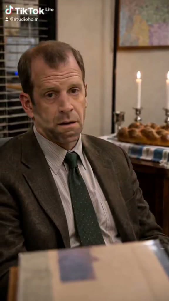 דמויות The Office סביב שולחן שבת.