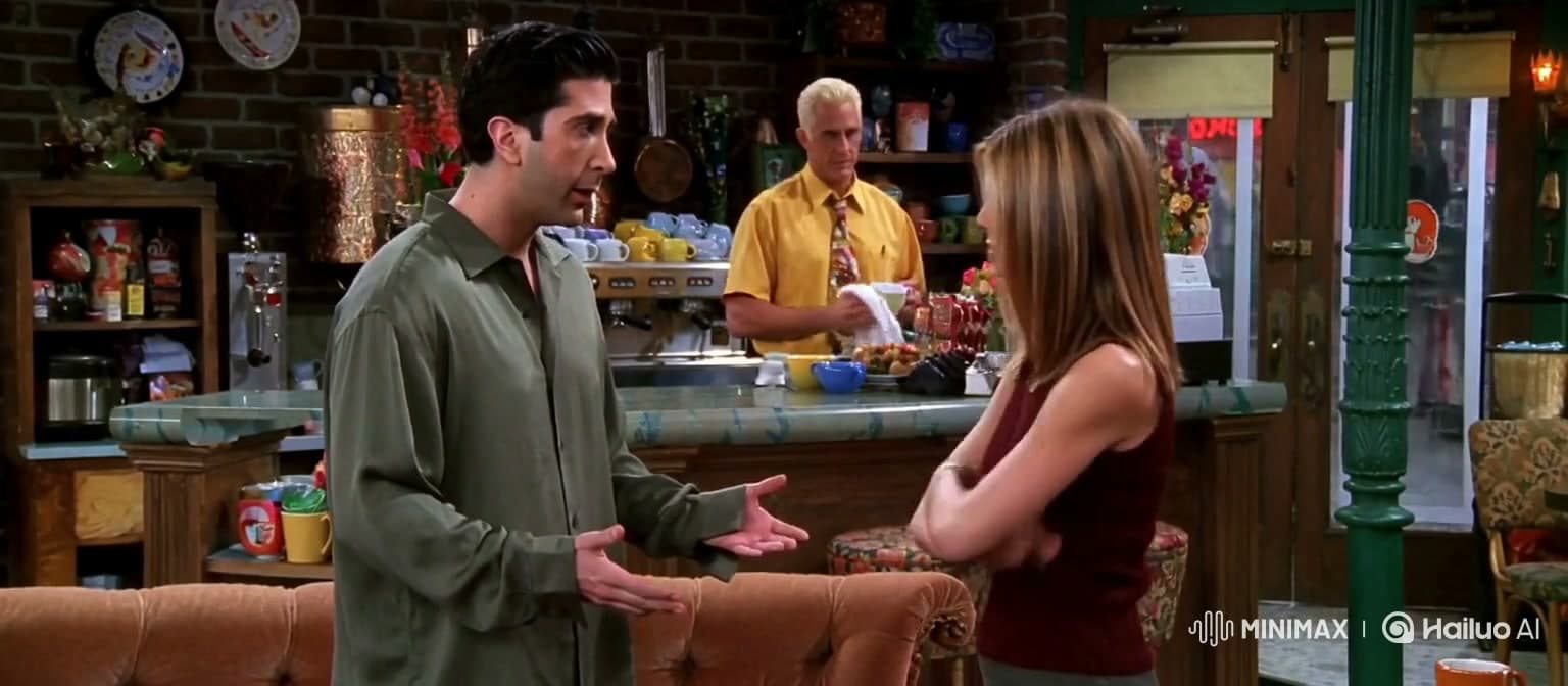 רוס ורייצ׳ל בקדמת Central Perk וגאנטר מאחורי הדלפק.